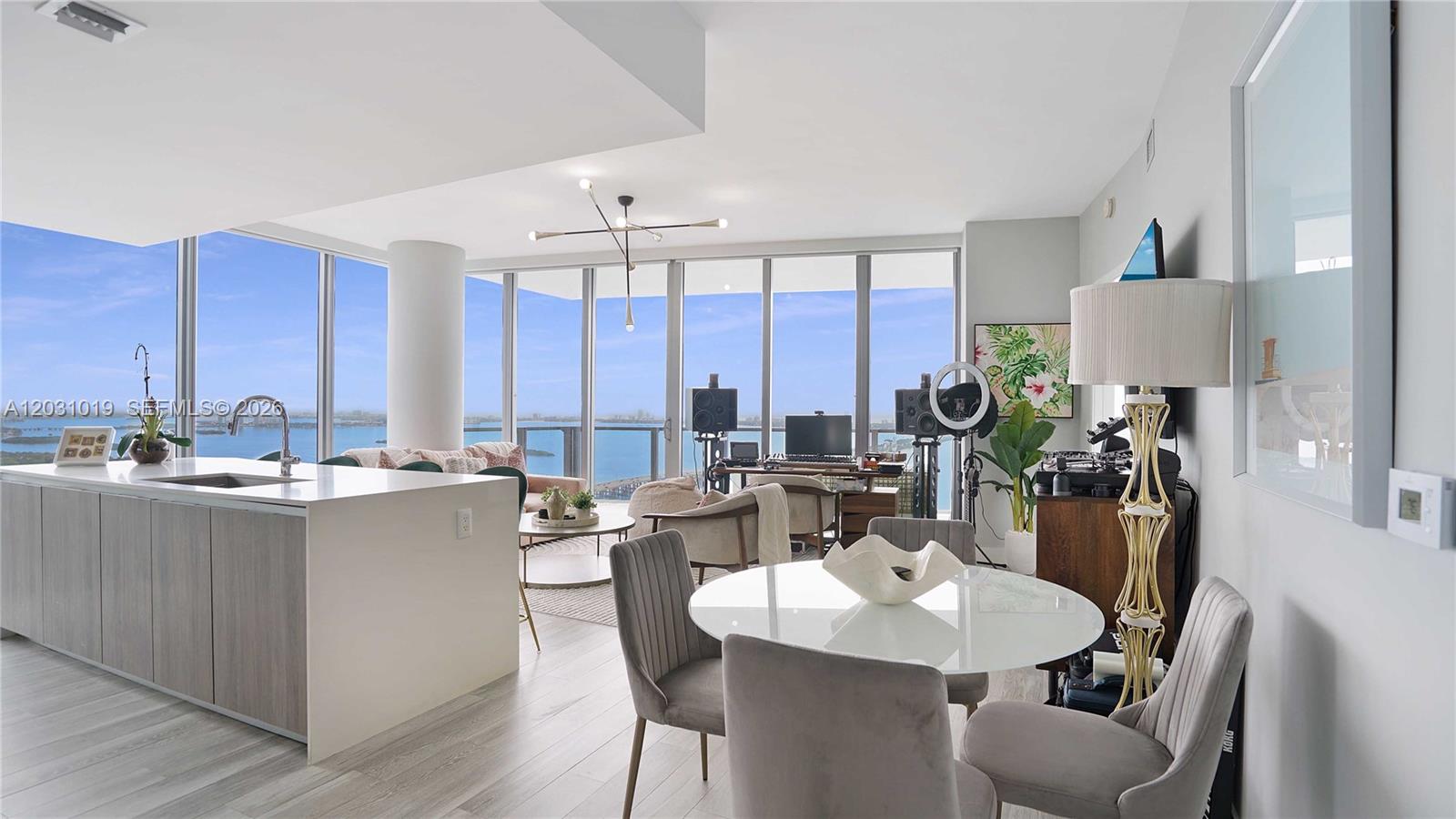 A modern open-concept living and dining area features floor-to-ceiling windows with expansive water views — 2900 NE 7th Ave # 4102, Miami FL 33137, MIAMI, FL
