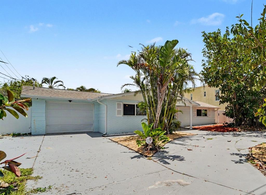 A single-story house with light blue siding, a blue front door, and a concrete driveway — 13714 ALLYN DRIVE, HUDSON, FL