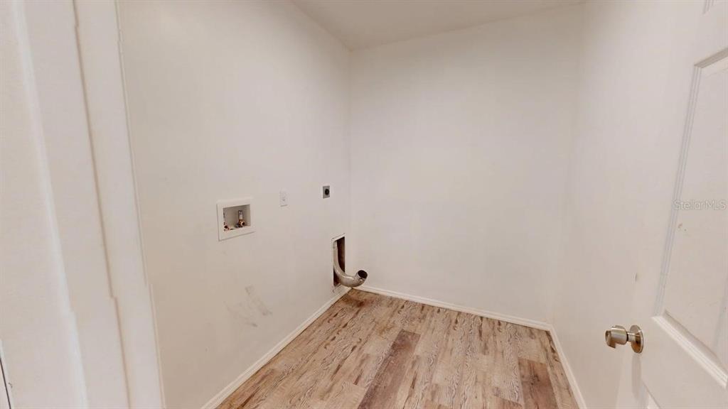 A laundry room with white walls, wood-look flooring, and utility hookups for a washer and dryer — 6217 JASON STREET UNIT 1, ORLANDO, FL