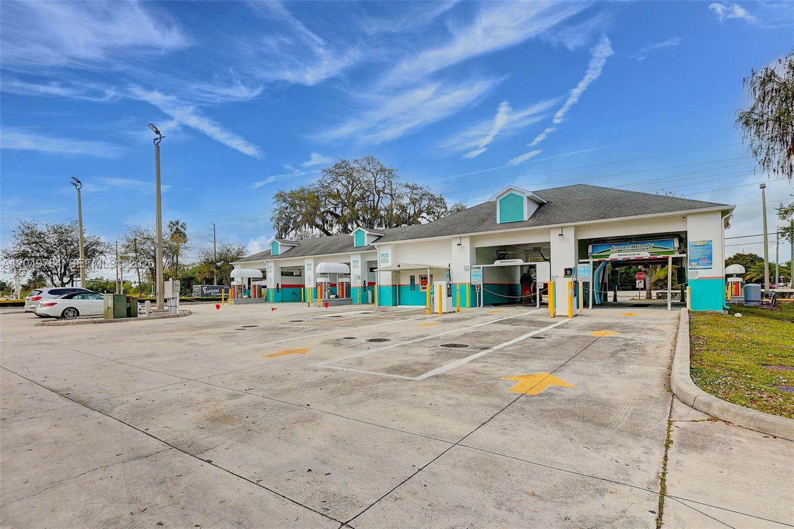 An exterior view of a multi-bay car wash facility with a concrete parking area — 3901 Orange Ave, Fort Pierce FL 34947, FORT PIERCE, FL