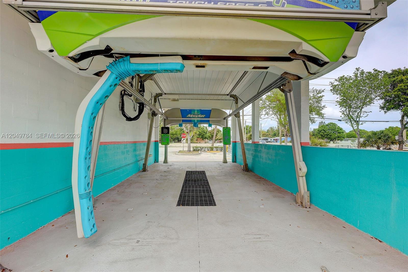 This is an outdoor car wash bay featuring a touchless cleaning system and concrete walls — 3901 Orange Ave, Fort Pierce FL 34947, FORT PIERCE, FL
