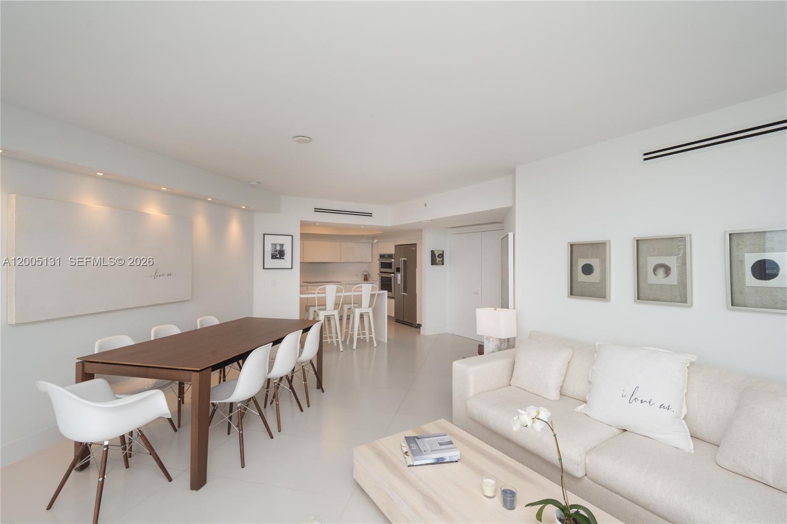 A bright, open-concept living and dining area features white walls, tile floors, and modern furniture — 6301 Collins Ave # 3006, Miami Beach FL 33141, MIAMI BEACH, FL