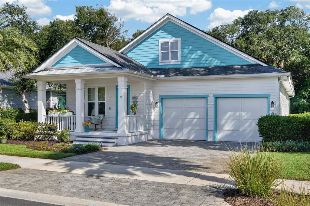 A single-story house with white siding, blue gables, a front porch, and a two-car garage — 46 HIDDEN TREASURE DRIVE, PALM COAST, FL