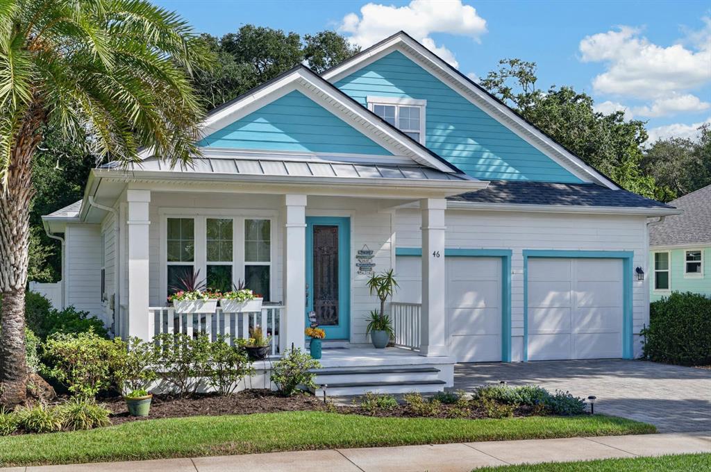A one-story house with white siding, a turquoise gable, a front porch, and a two-car garage — 46 HIDDEN TREASURE DRIVE, PALM COAST, FL