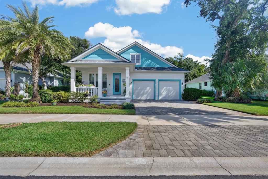 A two-story house with a turquoise gable, white siding, a front porch, and a driveway — 46 HIDDEN TREASURE DRIVE, PALM COAST, FL