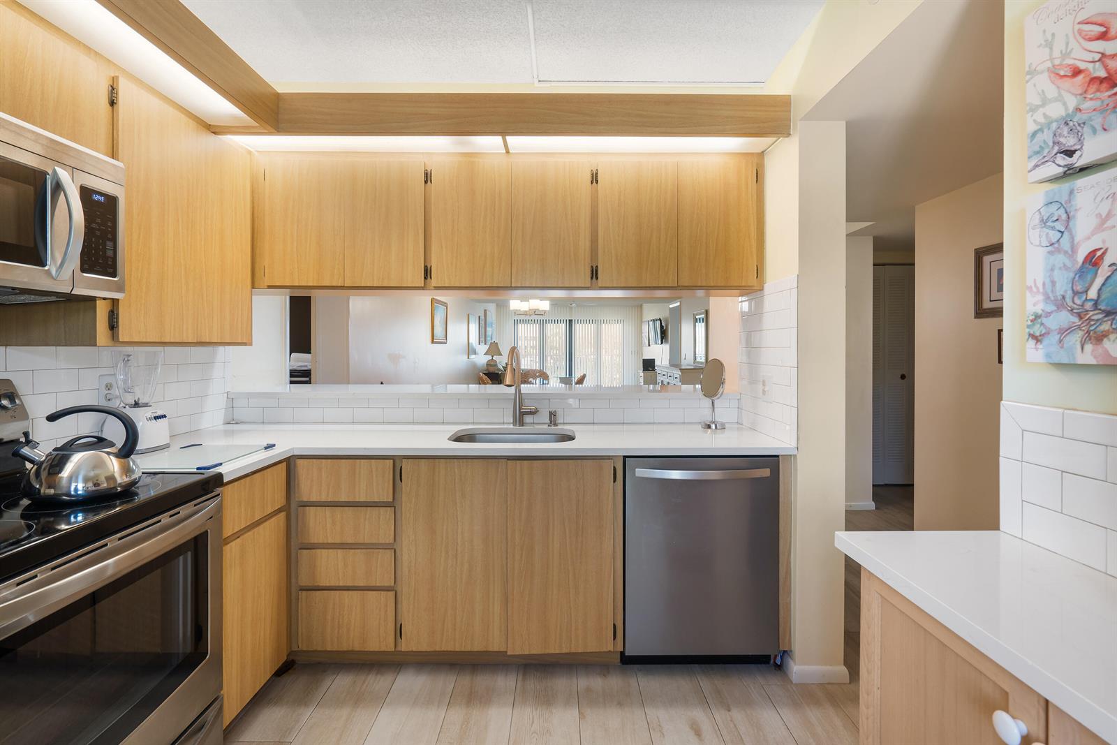 A kitchen with light wood cabinets, white countertops, stainless steel appliances, and a subway tile backsplash — 901 Seafarer Circle # 306, Jupiter FL 33477, JUPITER, FL