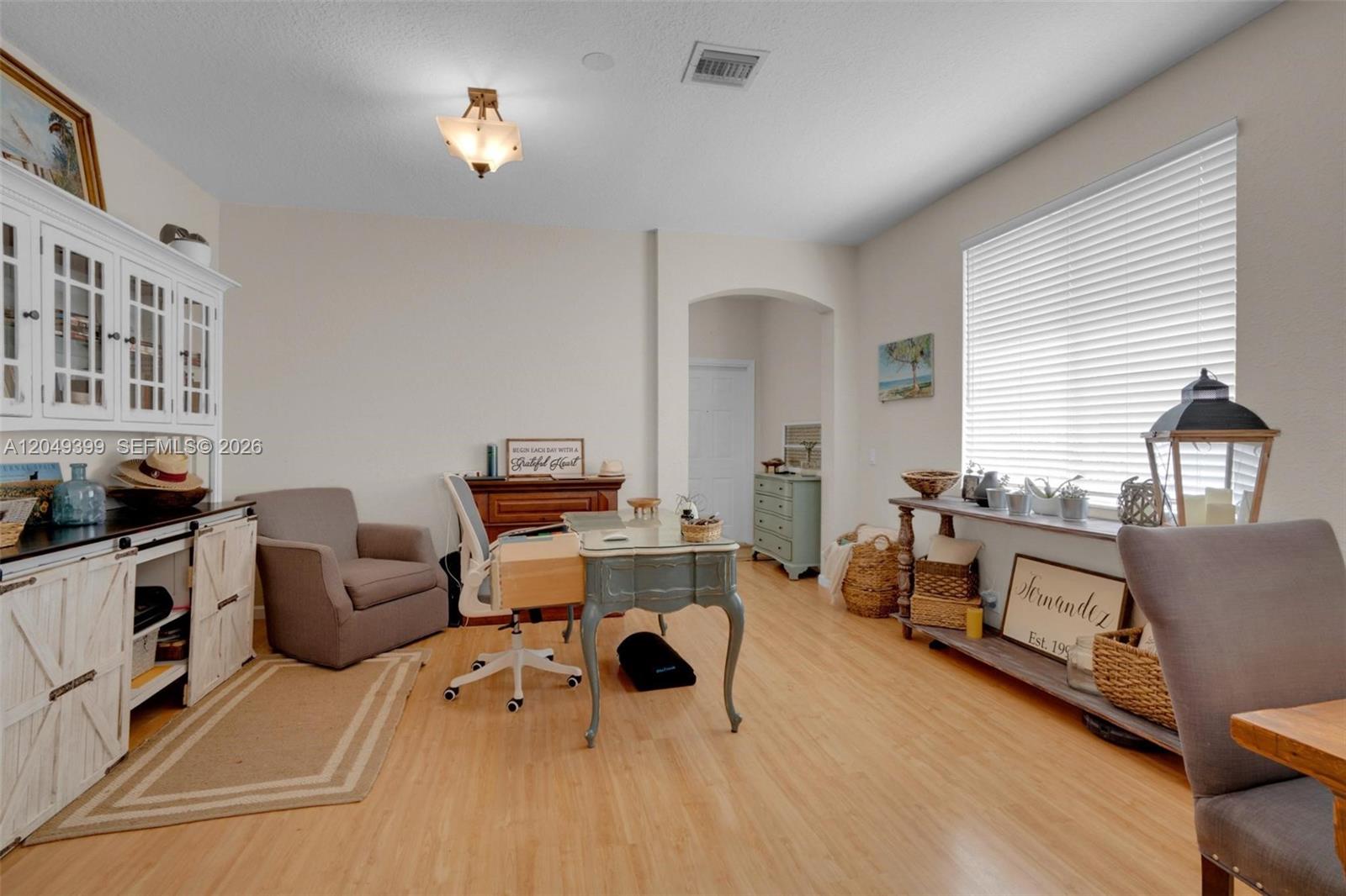 A home office features a desk, an armchair, a white hutch, and light wood flooring — 899 Phoenix Way, Weston FL 33327, WESTON, FL