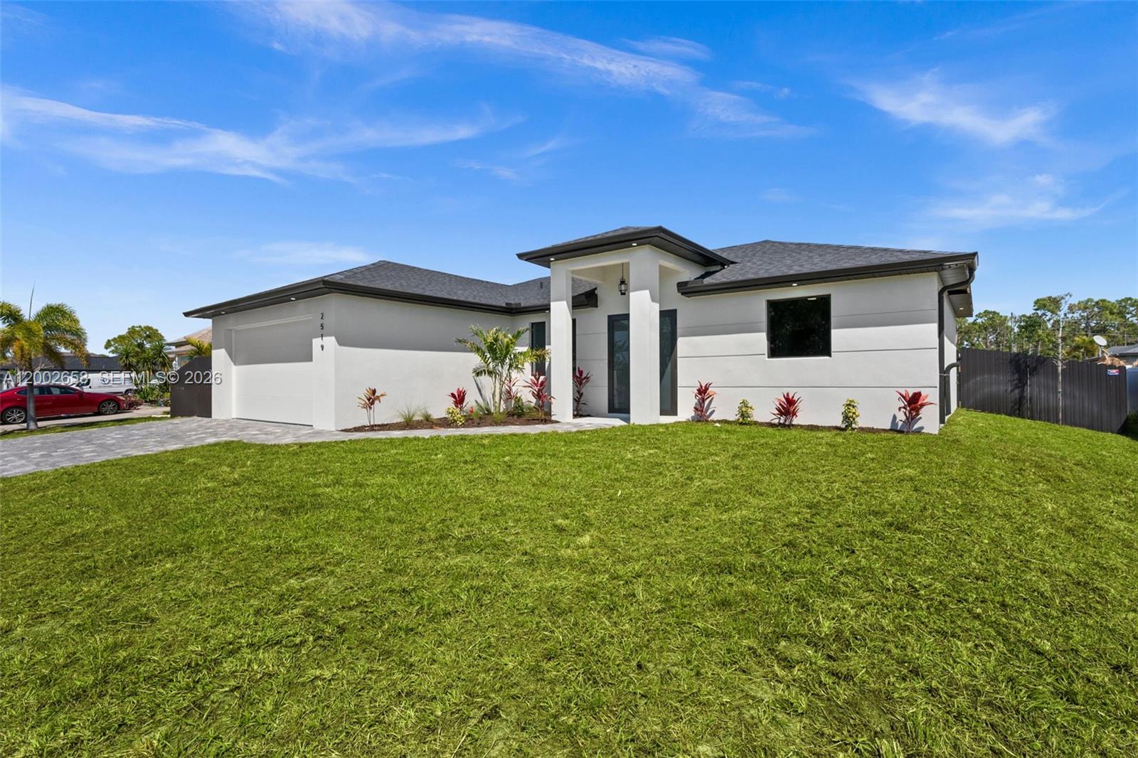 A modern, single-story white house with a dark roof and a two-car garage — 2519 NW 18TH, Cape Coral FL 33993, CAPE CORAL, FL
