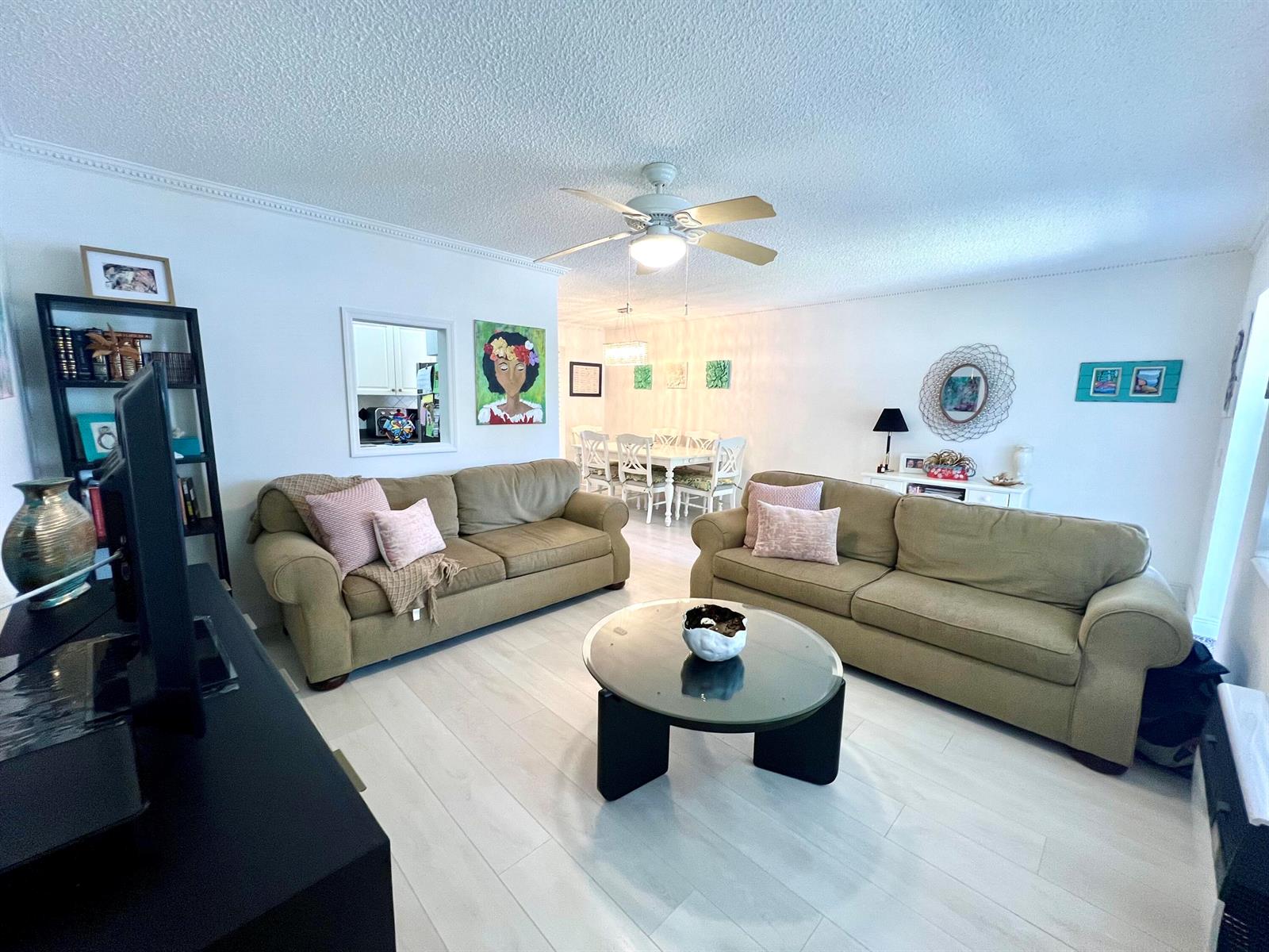 A living room features two tan sofas, a glass coffee table, and light wood flooring — 635 Durham W, Deerfield Beach FL 33442, DEERFIELD BEACH, FL