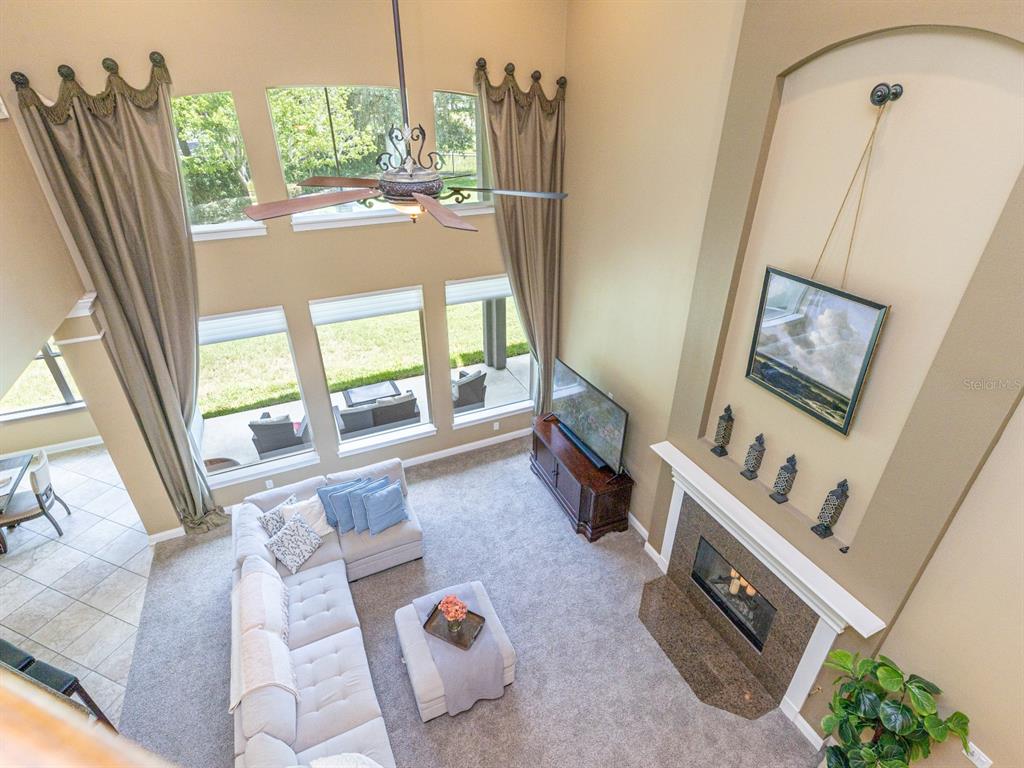 An aerial view of a two-story house with a stone facade and a paved driveway — 25846 FEATHER RIDGE LANE, SORRENTO, FL