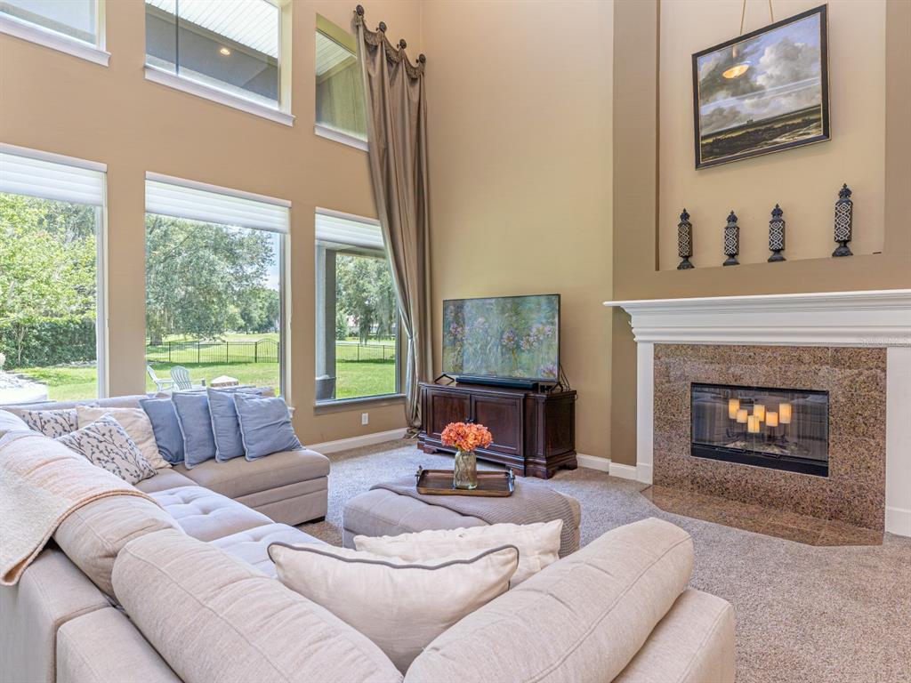 A house exterior features a stone-accented facade, a herringbone-patterned paver driveway, and a garage — 25846 FEATHER RIDGE LANE, SORRENTO, FL