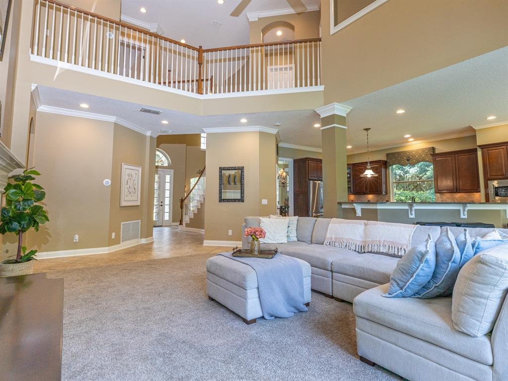 The rear exterior of a two-story house features a covered patio, large windows, and a chimney — 25846 FEATHER RIDGE LANE, SORRENTO, FL