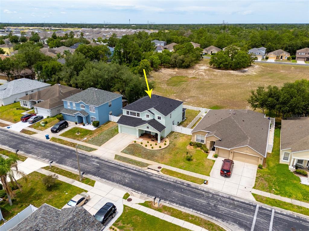 An aerial view shows a two-story light green house with a dark shingled roof — 4215 MAPLEHURST WAY, SPRING HILL, FL