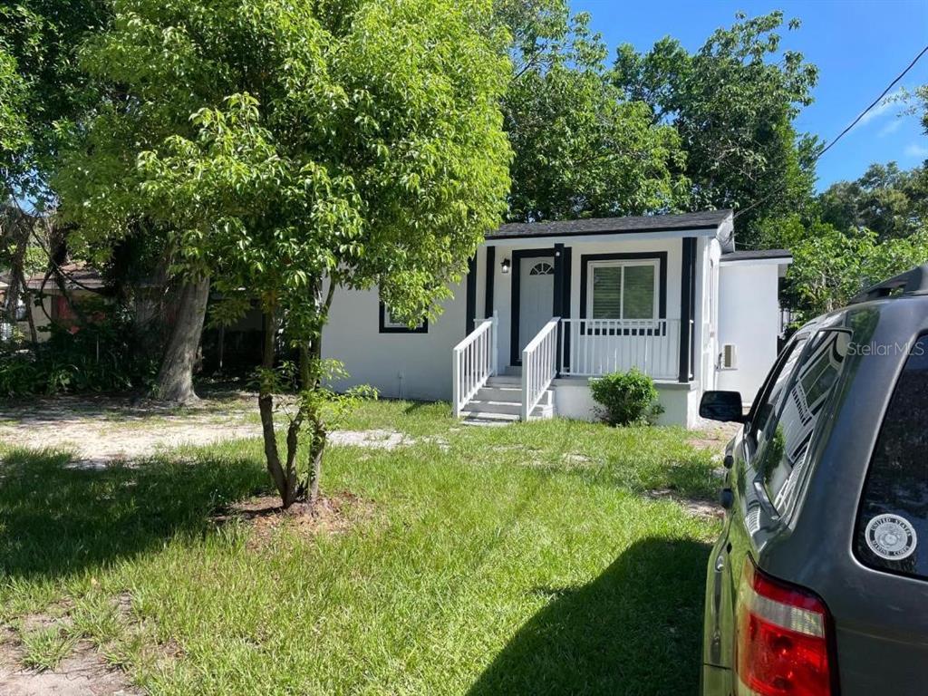 A white single-story house with a small front porch and a tree in the yard — 1812 E OKALOOSA AVENUE, TAMPA, FL