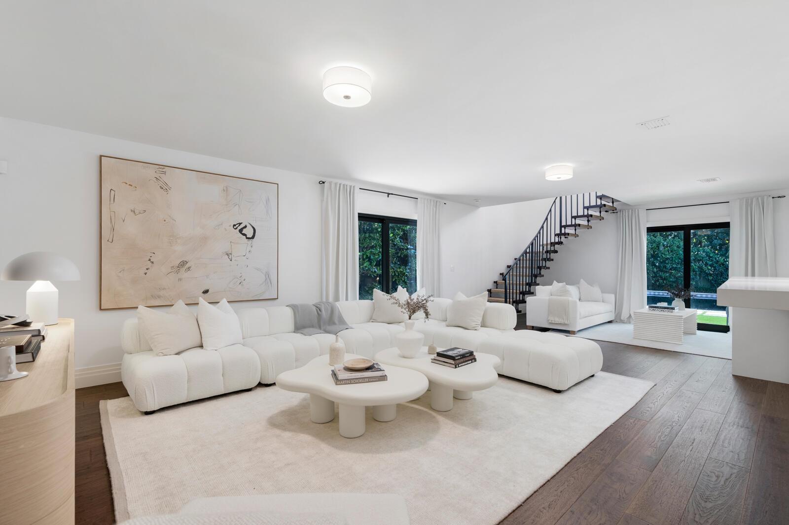 A bright living room features a large white sectional, two organic coffee tables, and a staircase — 1435 N Ocean Way, Palm Beach FL 33480, PALM BEACH, FL