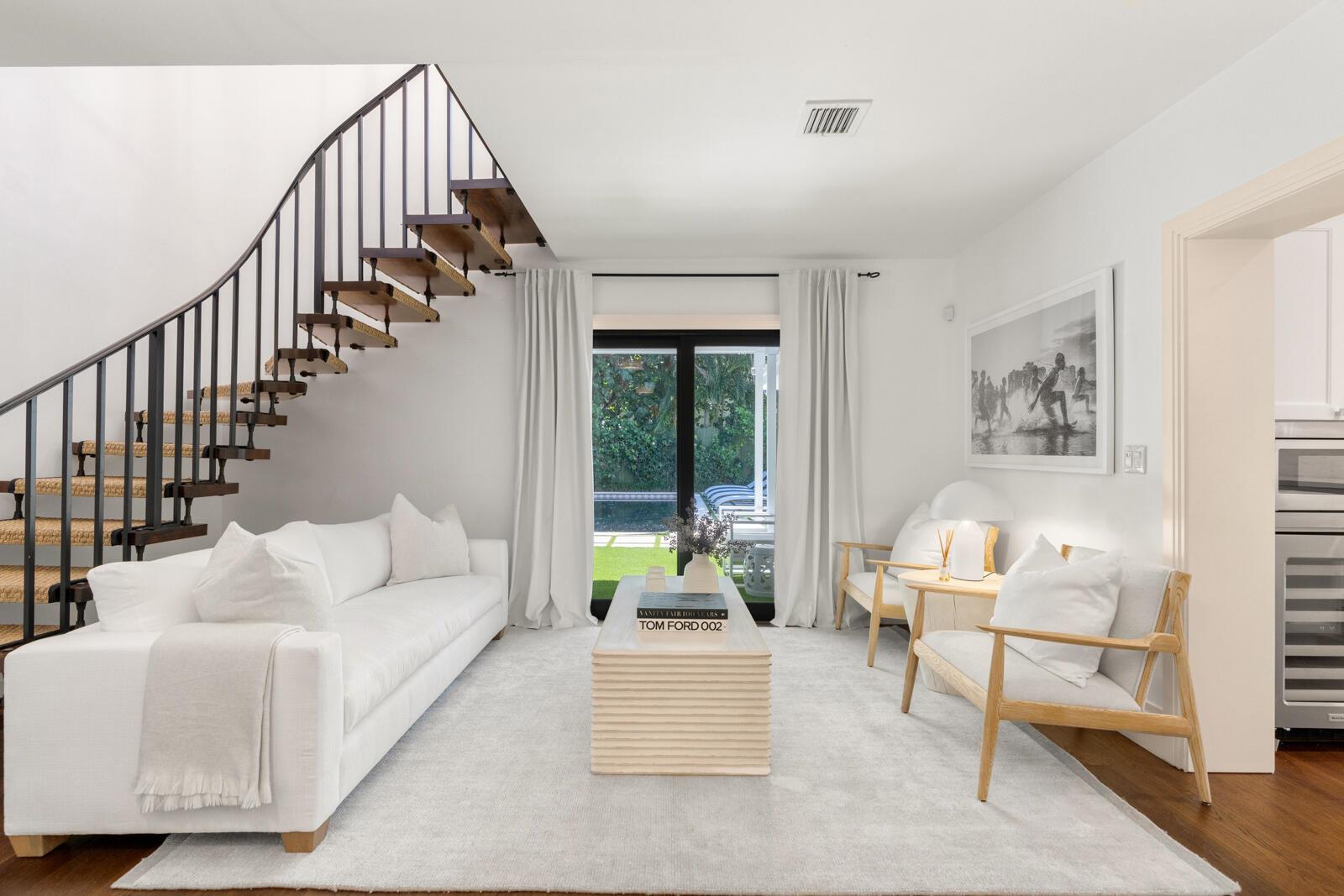 A modern living room features a white sofa, two wooden chairs, and a floating staircase — 1435 N Ocean Way, Palm Beach FL 33480, PALM BEACH, FL