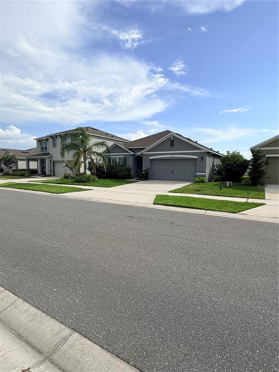 A gray single-story house with a two-car garage sits on a suburban street — 2665 NEVERLAND DRIVE, NEW SMYRNA BEACH, FL