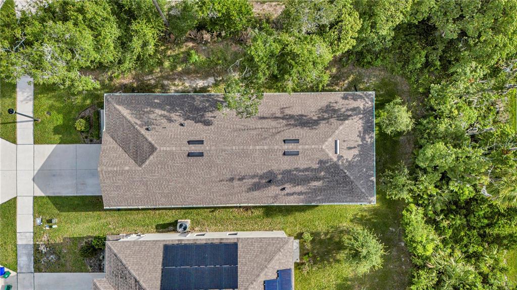 An aerial view shows the shingled roof of a house surrounded by trees and grass — 345 PELHAM PARK DRIVE, DELAND, FL