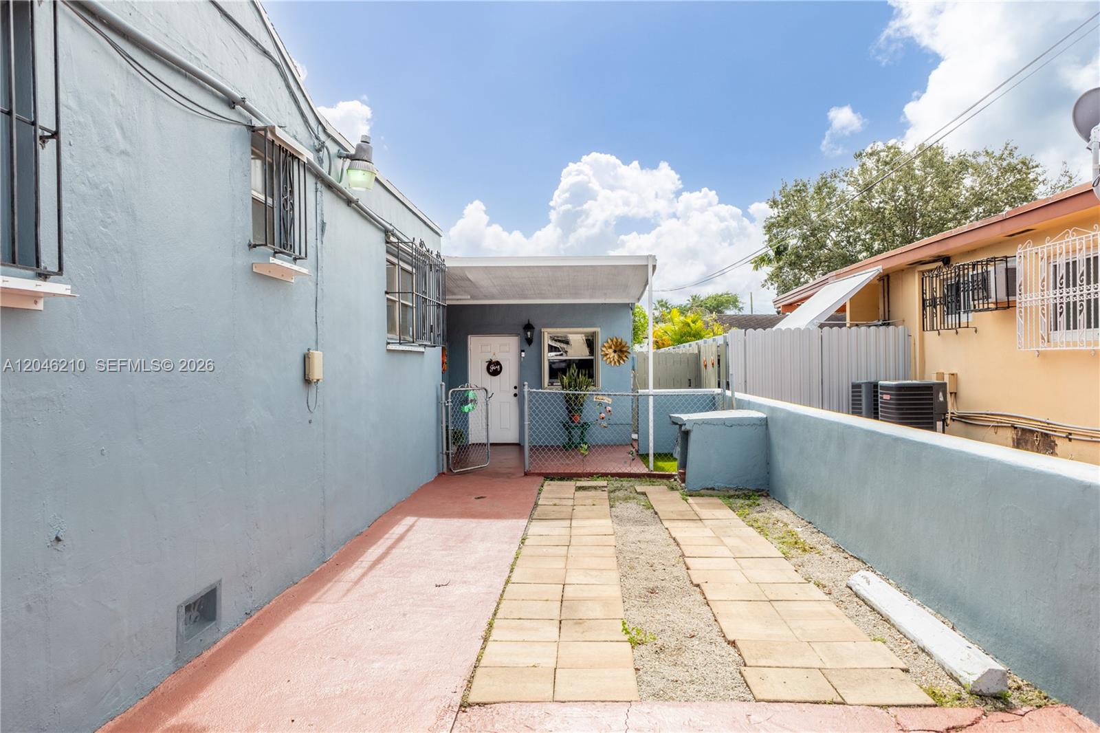 A paved driveway leads to the entrance of a blue house with a small porch — 2818 SW 2nd St, Miami FL 33135, MIAMI, FL