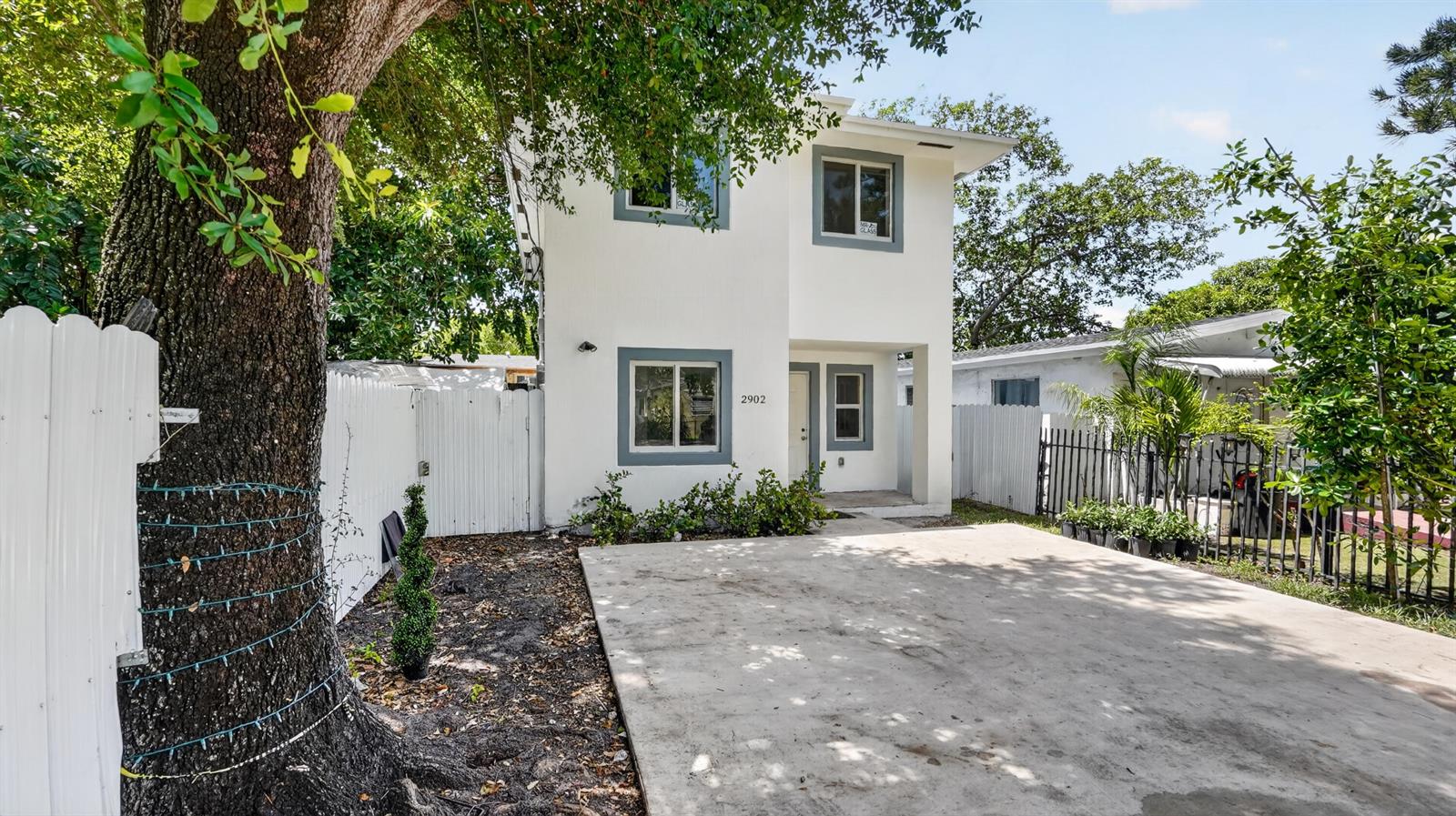 A two-story white house with gray window trim and a concrete driveway — 2902 NW 44th Street, Miami FL 33142, MIAMI, FL