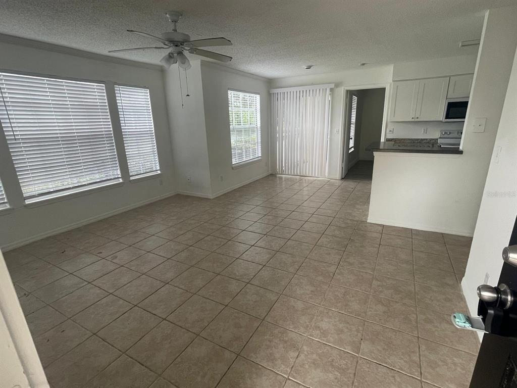 A two-story apartment building exterior features a black metal staircase and a black front door — 1069 S HIAWASSEE ROAD UNIT 1322, ORLANDO, FL