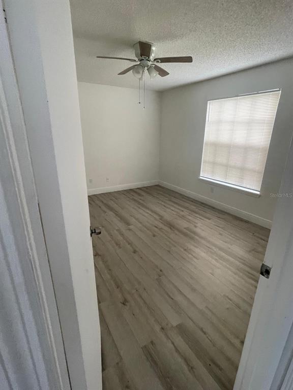 An open-concept living and dining area features tile flooring, a ceiling fan, and kitchen access — 1069 S HIAWASSEE ROAD UNIT 1322, ORLANDO, FL
