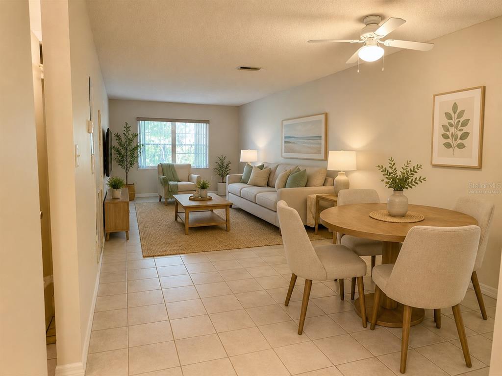 A living and dining area features tile flooring, a beige sofa, and a round table — 4746 AZALEA DRIVE UNIT 213, NEW PORT RICHEY, FL