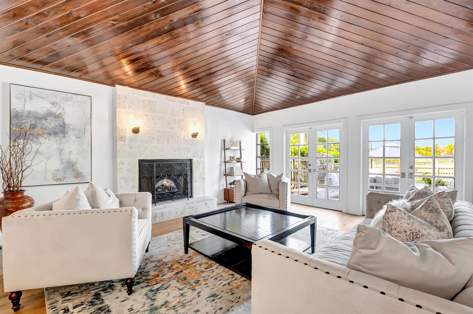 A living room features a vaulted wood-paneled ceiling, a stone fireplace, and white tufted sofas — 10321 El Paraiso Place S, Delray Beach FL 33446, DELRAY BEACH, FL