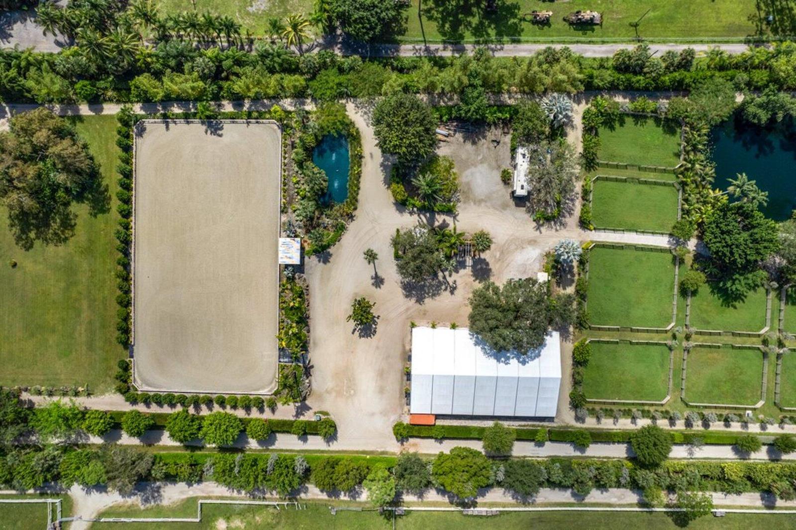 An aerial view shows an equestrian property with a riding arena, paddocks, and a tent — 1754 B Road, FL 33470, FL