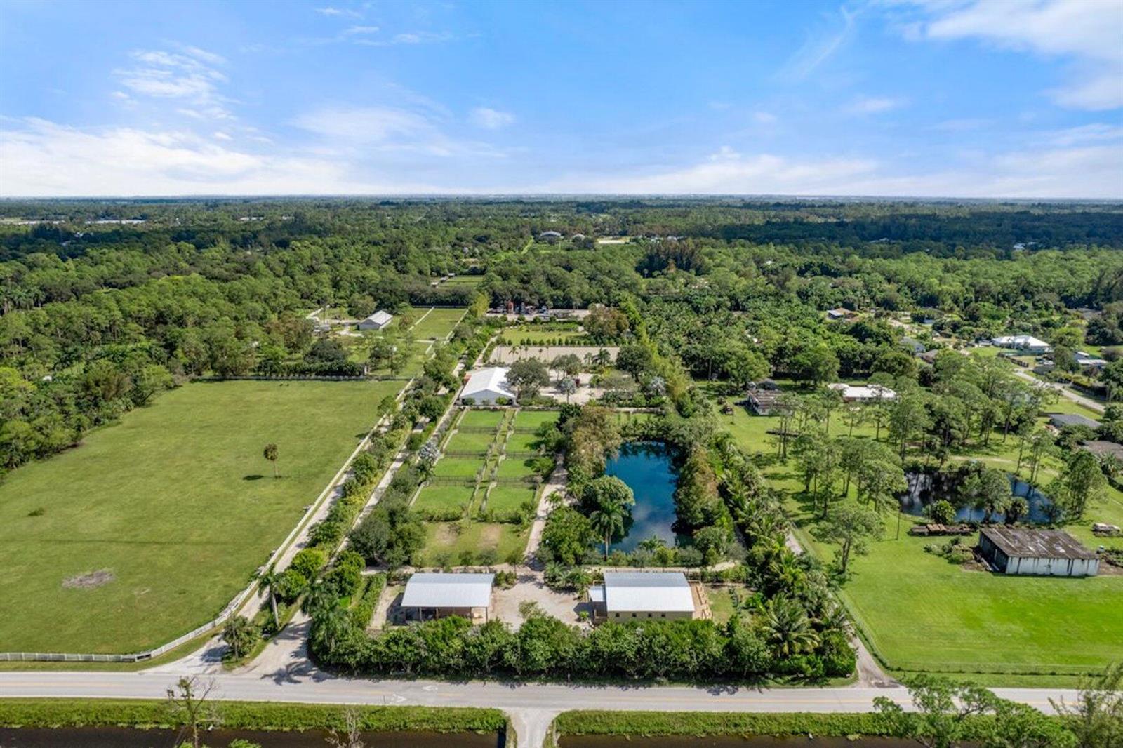 An aerial view shows a rural property with a pond, pastures, and several outbuildings — 1754 B Road, FL 33470, FL