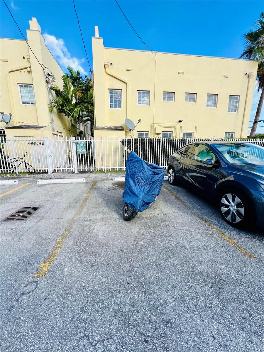 A parking lot with a covered motorcycle and a car sits before a yellow building — 600 Euclid Ave # 5A, Miami Beach FL 33139, MIAMI BEACH, FL
