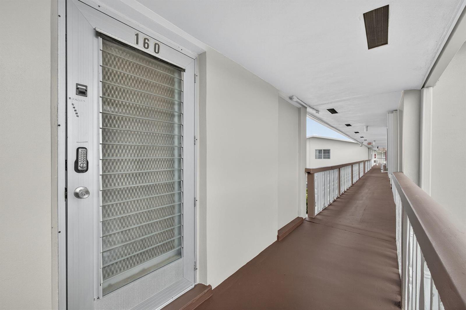 An exterior walkway leads to a door marked 160 with a white frame and screen — 160 Easthampton G, West Palm Beach FL 33417, WEST PALM BEACH, FL