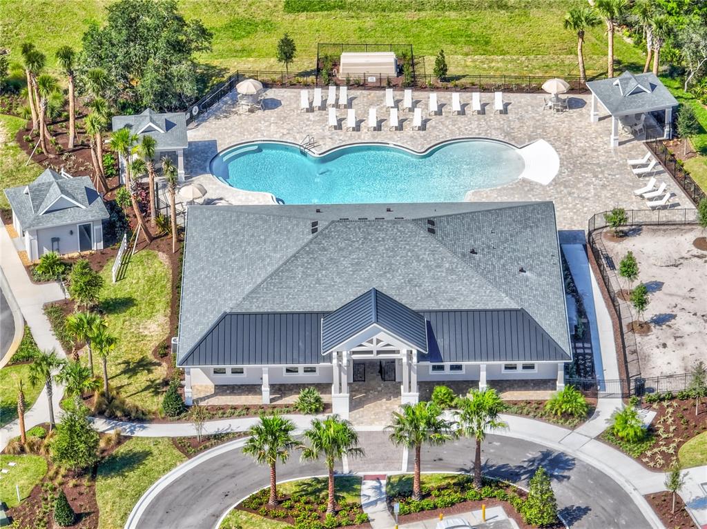 An aerial view shows a community clubhouse with a pool, patio, and surrounding landscaping — 1119 LILIANA DRIVE, DELAND, FL