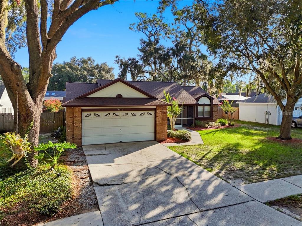 A single-story brick and siding house with a two-car garage and a concrete driveway — 4110 LONGFELLOW DRIVE, PLANT CITY, FL