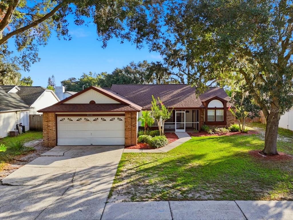 A single-story house with a two-car garage, a brick facade, and a front lawn — 4110 LONGFELLOW DRIVE, PLANT CITY, FL