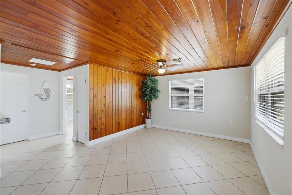 A room with tile floors, a wood-paneled ceiling, and a wood-paneled accent wall — 155 MAGNOLIA AVENUE, ENGLEWOOD, FL
