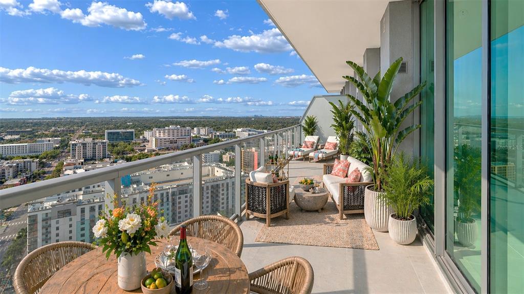 A high-rise balcony with a glass railing overlooks a city skyline under a blue sky — 400 CENTRAL AVENUE UNIT 2505, ST PETERSBURG, FL