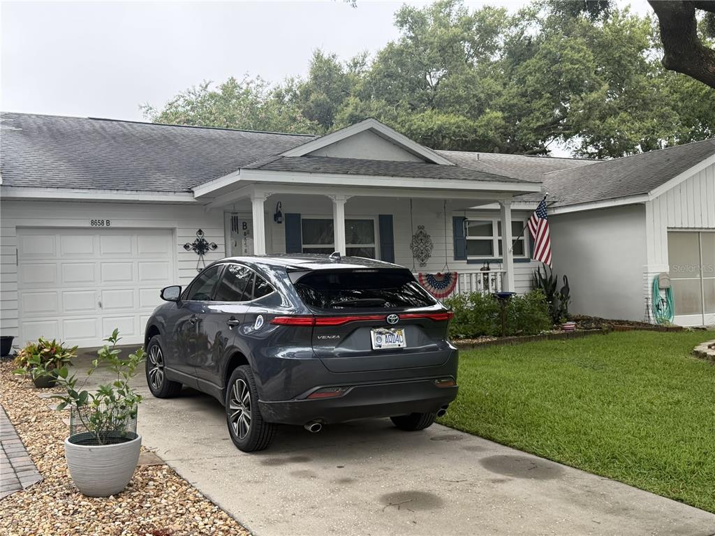 A gray SUV is parked in the driveway of a single-story house with white siding — 8658 SW 95TH LANE UNIT B, OCALA, FL