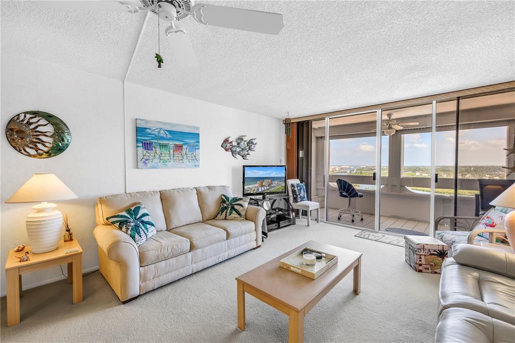 A living room features a beige sofa, a coffee table, and a balcony with views — 17920 GULF BOULEVARD UNIT 2006, REDINGTON SHORES, FL
