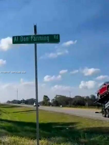 A street sign reading Al Don Farming Rd stands beside a road with a car carrier — 12305 E SR 80, Clewiston FL 33440, CLEWISTON, FL
