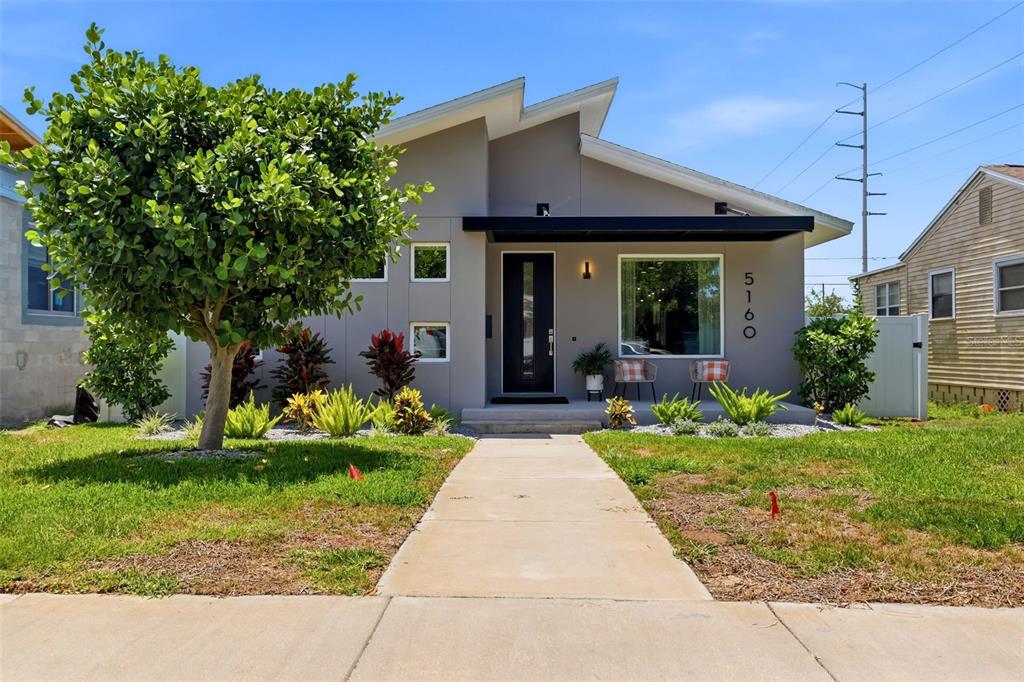 A modern, gray, single-story house with a flat roof and a concrete walkway — 5160 DARTMOUTH AVENUE N, ST PETERSBURG, FL