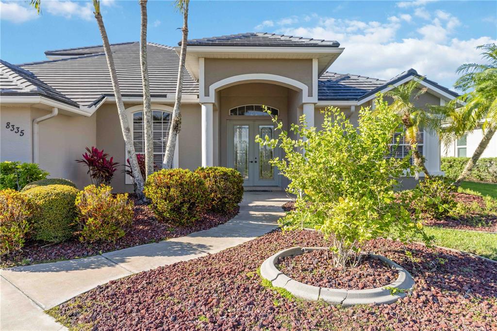 The exterior of a single-story house features a paved walkway leading to a double-door entrance — 8335 BARTON FARMS BOULEVARD, SARASOTA, FL