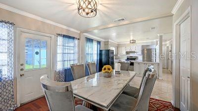 A dining room features a marble-topped table, upholstered chairs, and a view into the kitchen — 1104 FRUITLAND AVE., BRADENTON, FL