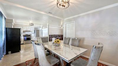 A dining area with a marble-topped table and gray chairs sits adjacent to a kitchen — 1104 FRUITLAND AVE., BRADENTON, FL