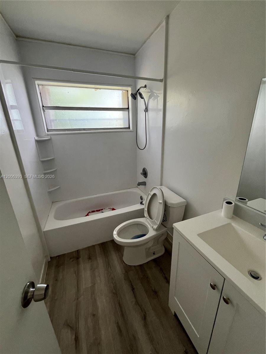 A small bathroom features a white vanity, a toilet, and a bathtub with a shower — 334 E 21st St # 3, Hialeah FL 33010, HIALEAH, FL