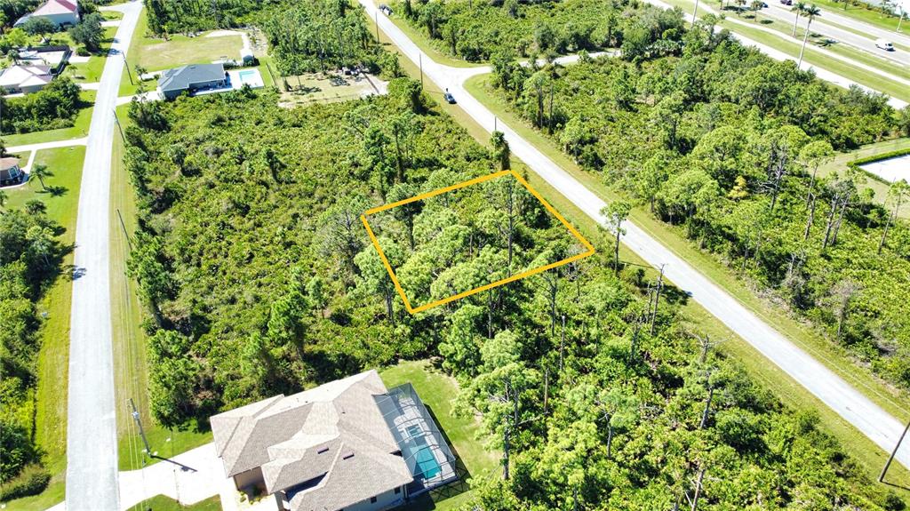 An aerial view shows a rectangular vacant lot outlined in yellow surrounded by dense vegetation — 8178 DIMSTEAD STREET, PORT CHARLOTTE, FL