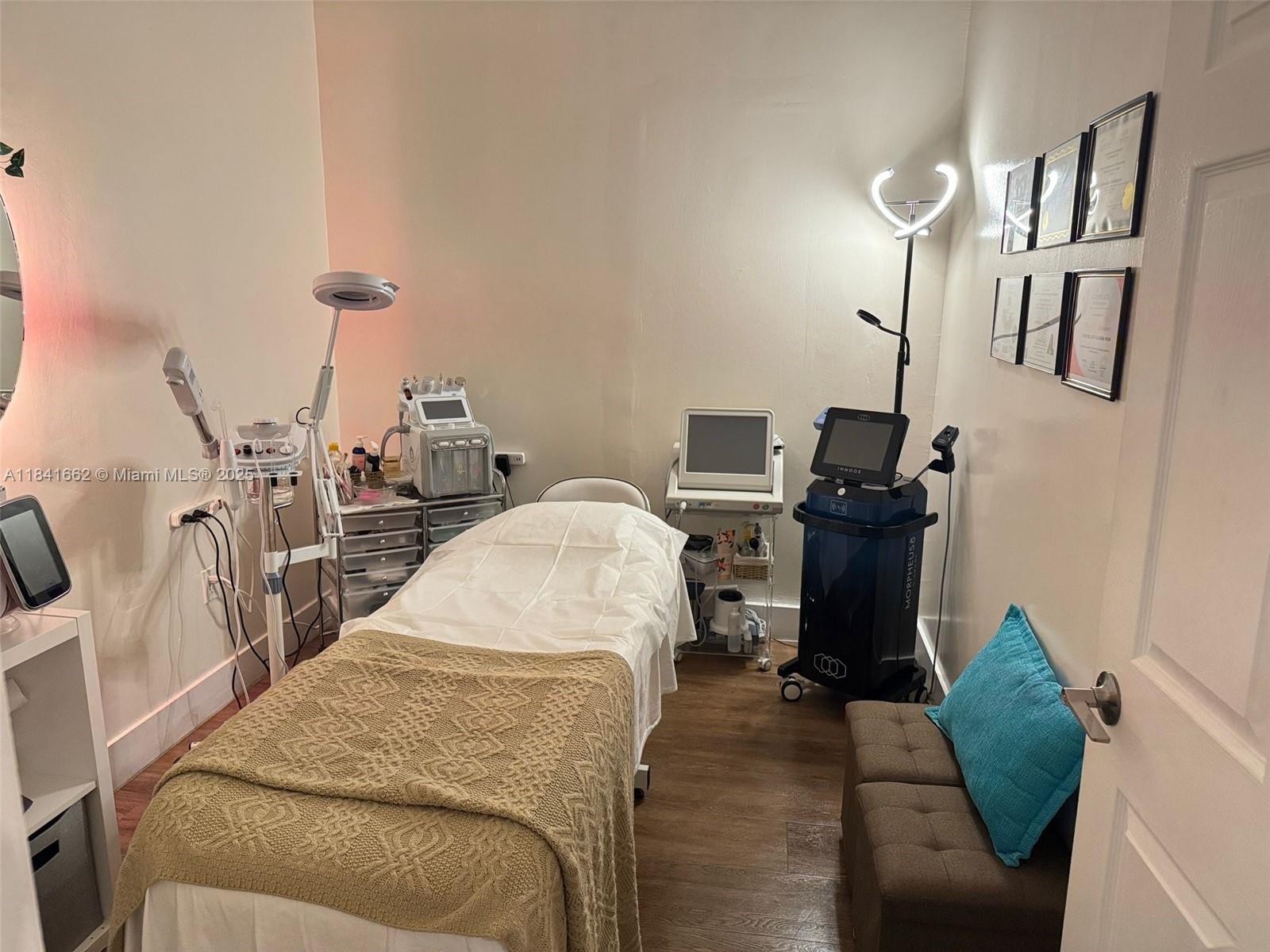 A treatment room features a massage table, medical aesthetic equipment, and framed certificates on the wall — 10328 W flagler st, Miami FL 33174, MIAMI, FL