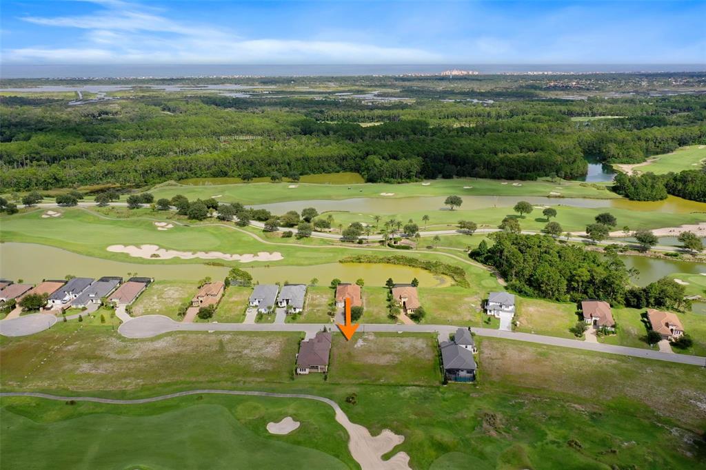 An aerial view shows a vacant residential lot situated between two houses on a golf course — 342 HIBISCUS WAY, PALM COAST, FL