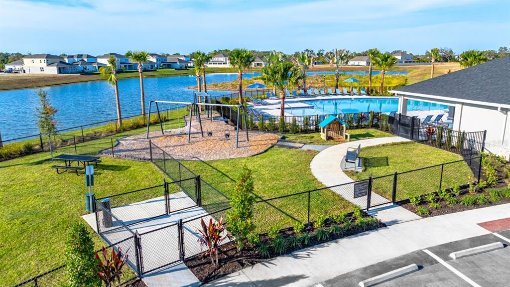 An outdoor community area features a fenced playground, a swimming pool, and a lake view — 5120 SLATE HUE PLACE, APOLLO BEACH, FL