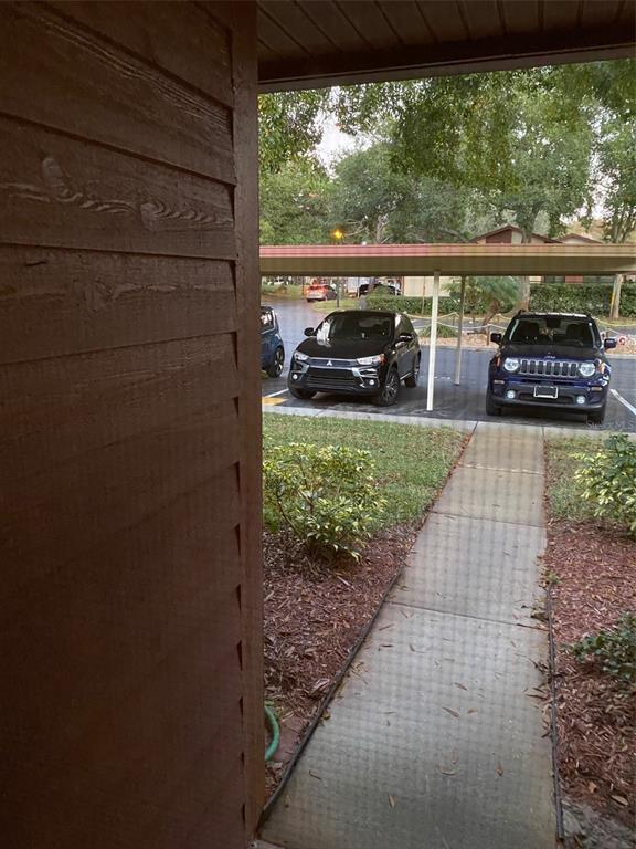 A view from a doorway looking out at a sidewalk, parking area, and two cars — 12539 GREYLOCK LANE, HUDSON, FL